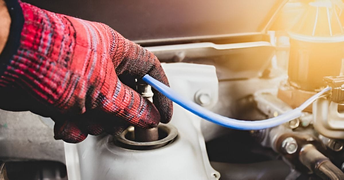 A person in a red stripe gloves checking the O2 sensor of a car
