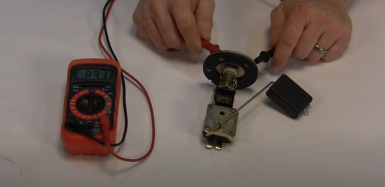 mechanic testing gauge using multimeter