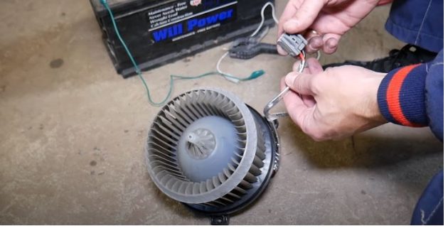 mechanic's hand checking the car's blower