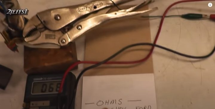 multimeter with its probes attached to gauge