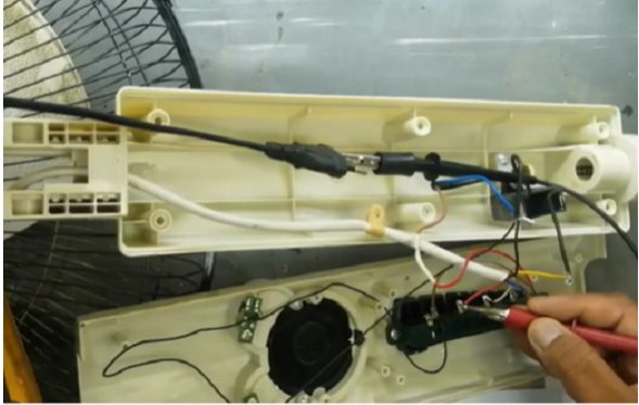 red probe of multimeter on electric fan wire