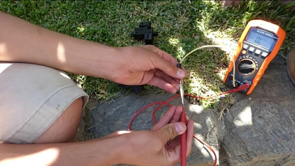 man testing the power switch with multimeter