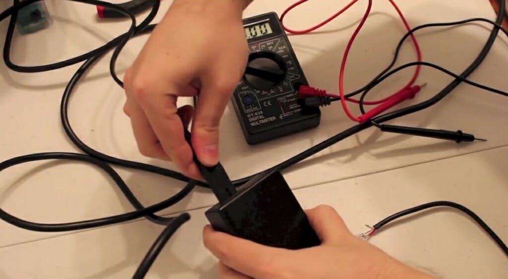 technician connecting regulator to a 12V power supply