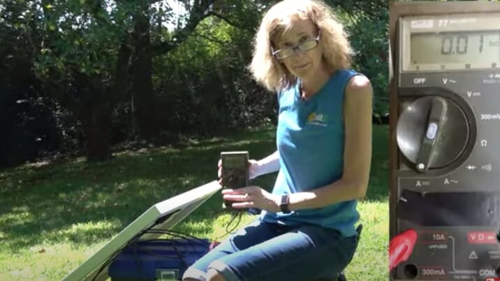 woman testing her solar panel with multimeter