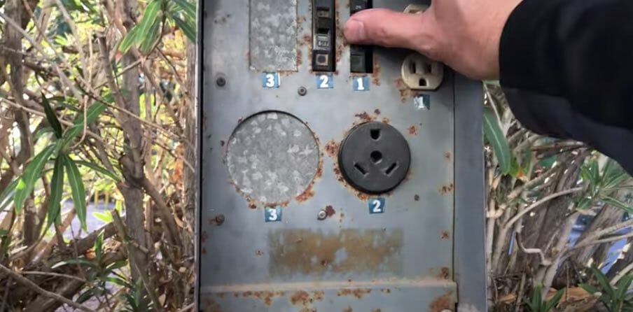 A person holding an RV outlet switch