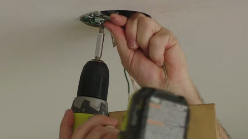 connecting the wires and screwing at the ceiling to secure