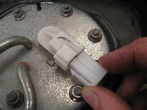 A person is holding a fuel pump without its wire