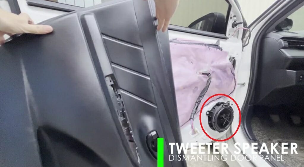 man dismantling a door panel of a cara door panel of a car