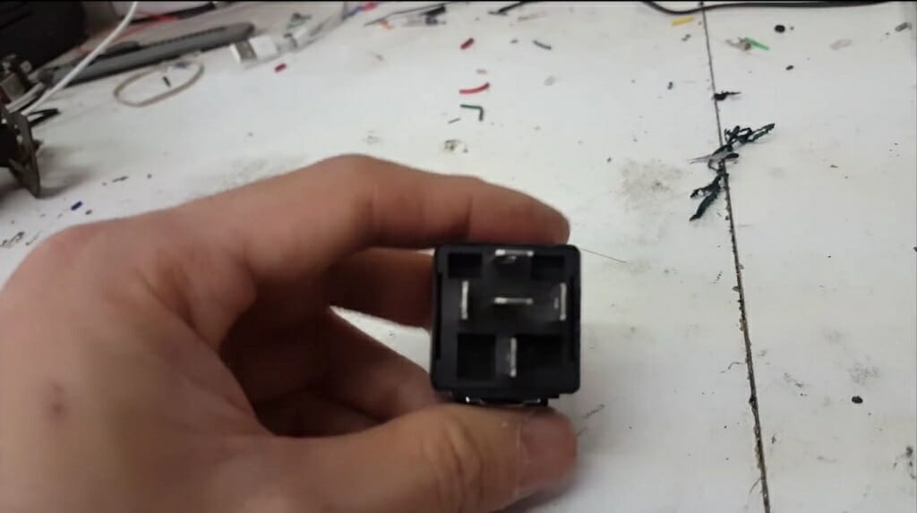man holding 5-pin relay