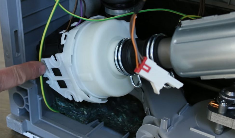 man taking out the pump motor of a dishwasher