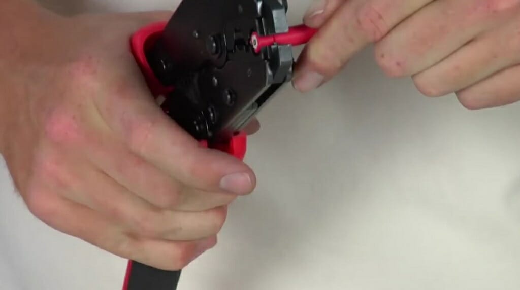 man stripping wire using wire stripper tool