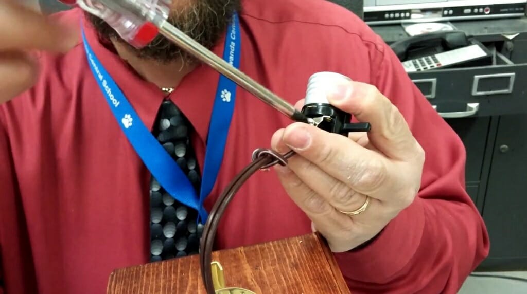 taking the bent hot wire and place it on the gold terminal then, tighten the screw