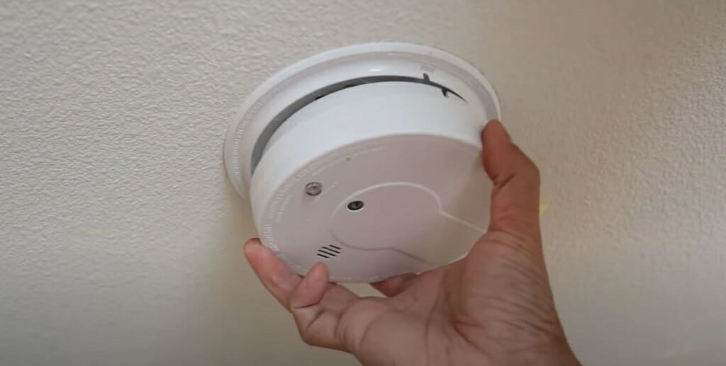 twisting the smoke alarm onto the mounting bracket
