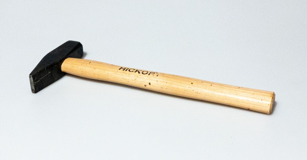 A HICKOP tack hammer on a grayish background