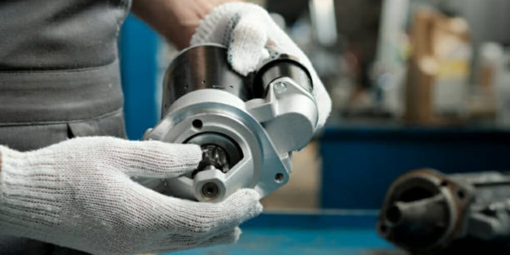 mechanic holding a car starter