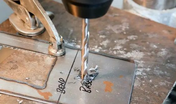 drill press drilling on metal slate