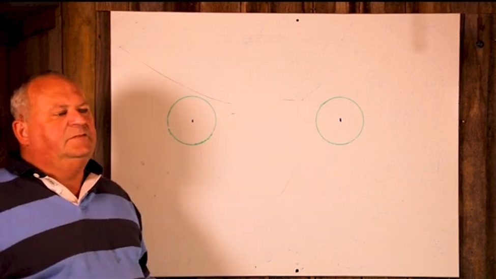 man beside a cardboard template with two holes