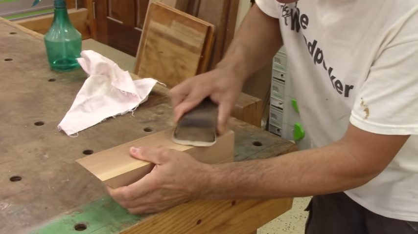 man cleaning the surface of the wood