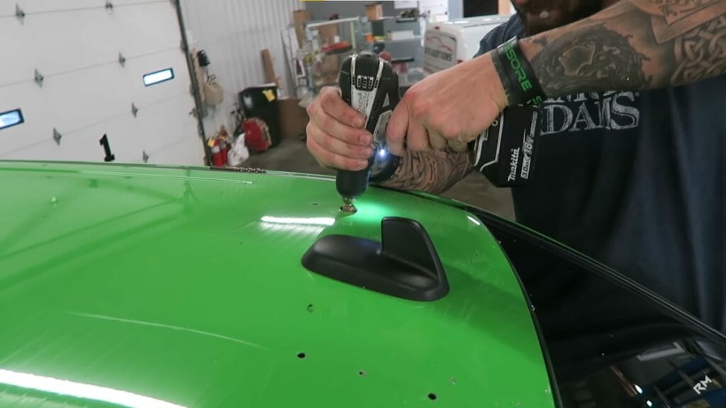 man drilling the car roof