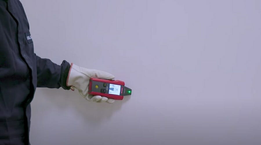 man with safety gloves holding a signal cable locator