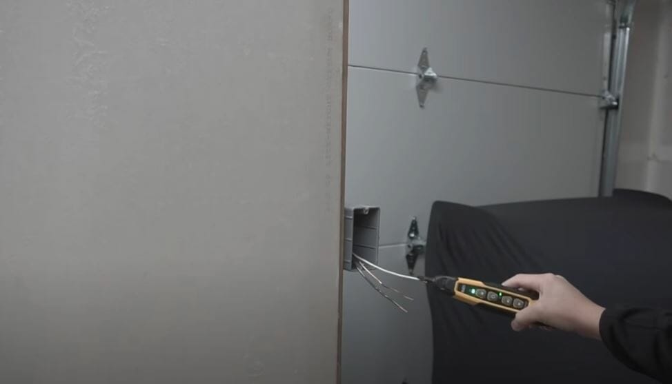 A person tracing a broken wire using a tool