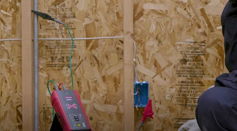 A person tracing wire using a signal cable locator