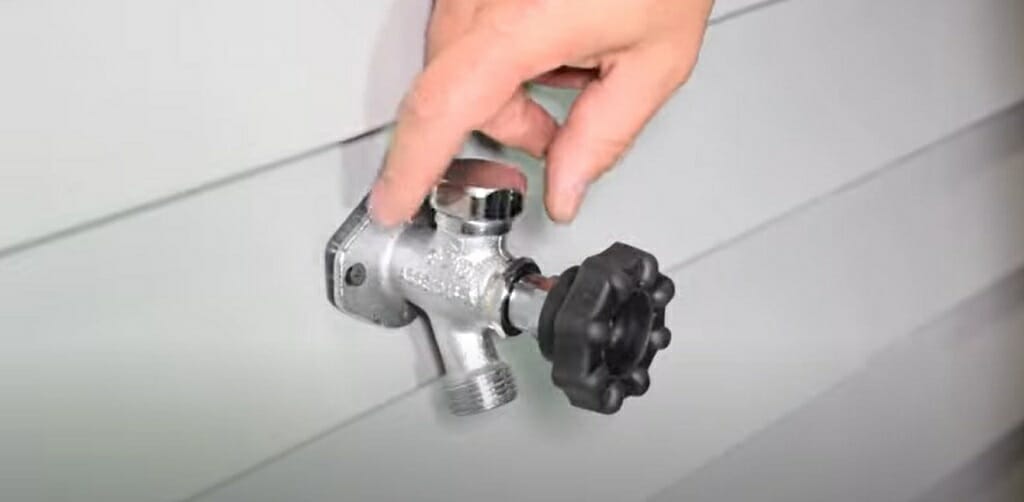 a person turning off the water valve