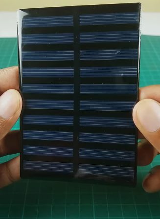 A person holding a mini solar panel 
