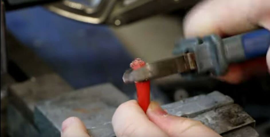 A person stripping the insulation off the end of the wire