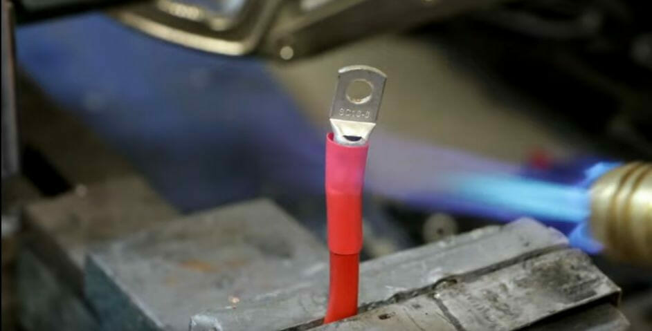 A person is heating the heat shrink tube