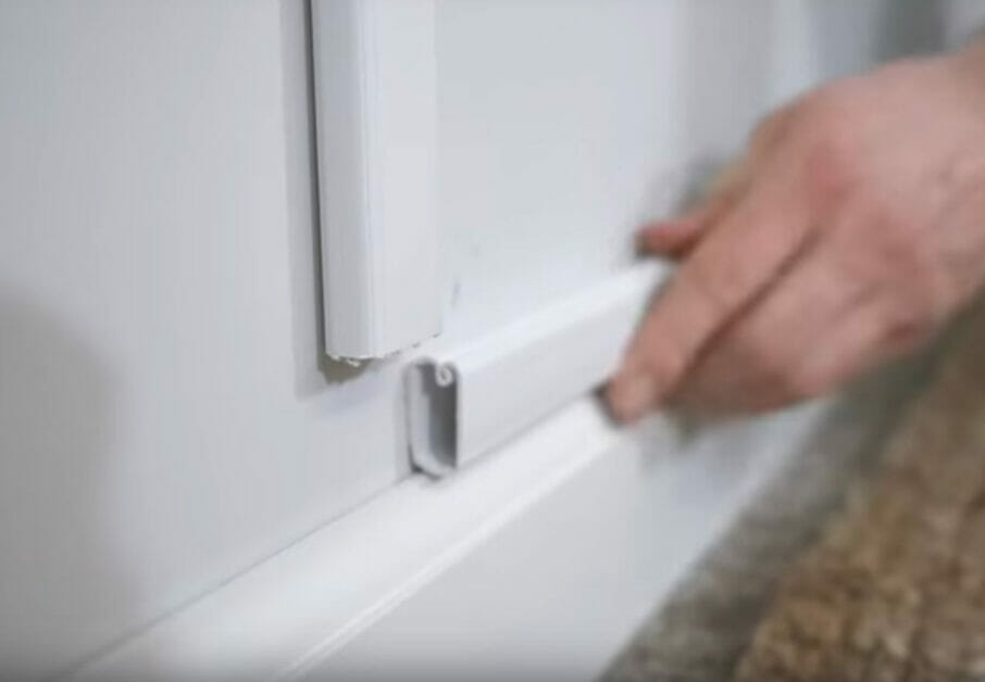 A person is holding a conduit to conceal wires
