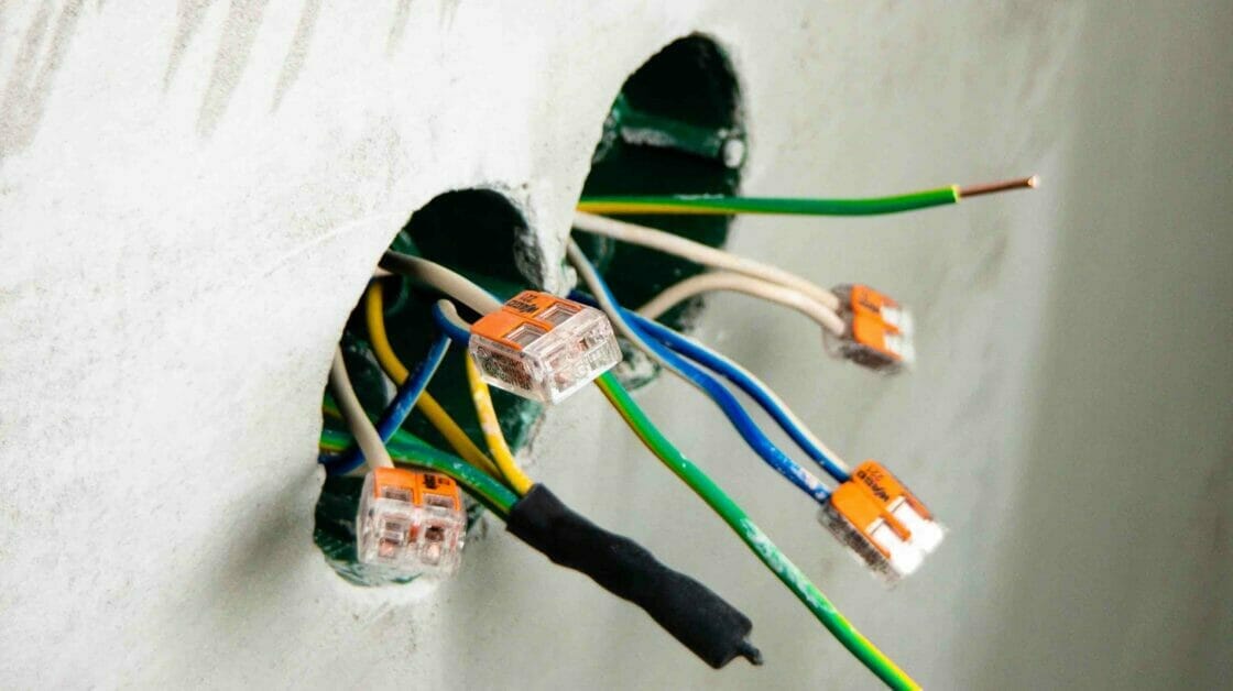 undone and uncovered capped wires on wall