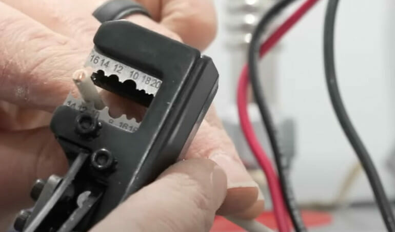 A person using a wire cutter to cut a wire