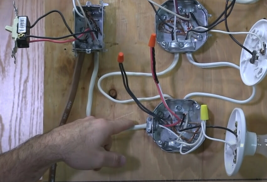 A person charting the path of a light switch wiring