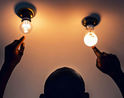 A man pointing at two on light fixtures at the ceiling