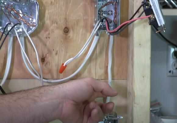 A person holding a white wire