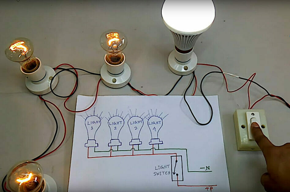 A person demonstrating the series wiring of a bulb light