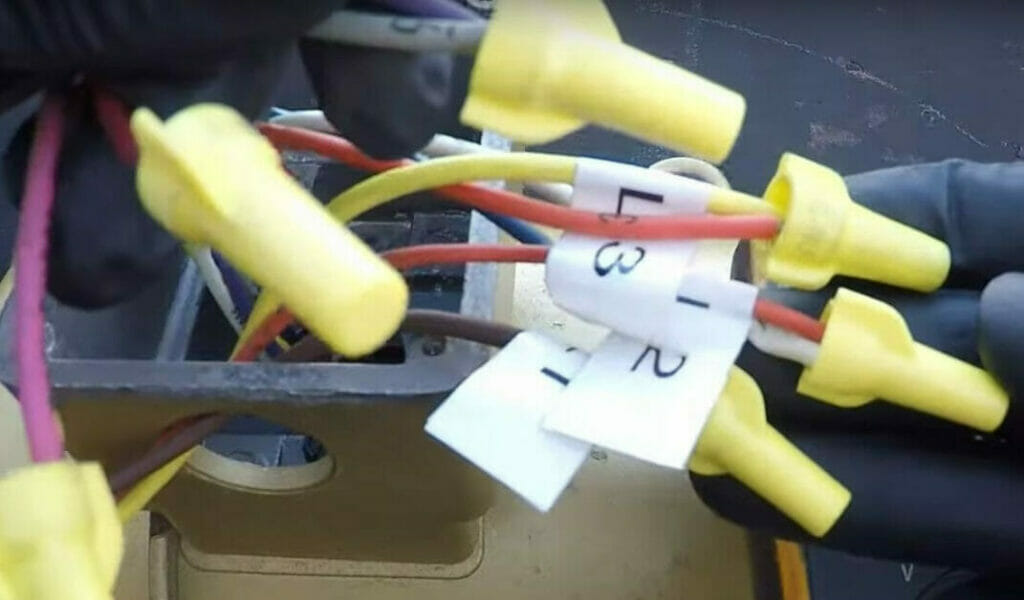 A person holding a capped wires with labels in it