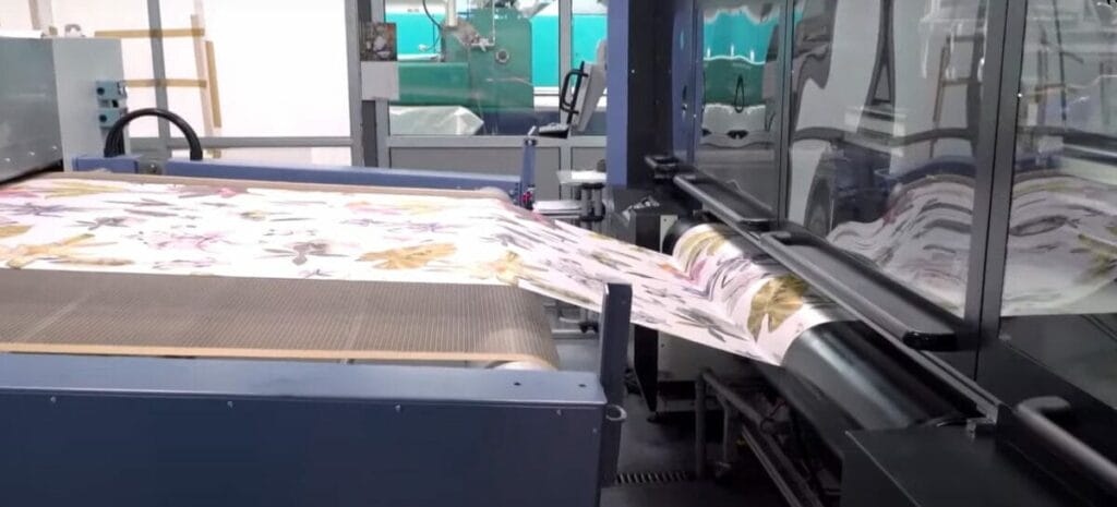 A digital fabric printing machine is cutting a piece of fabric in a factory