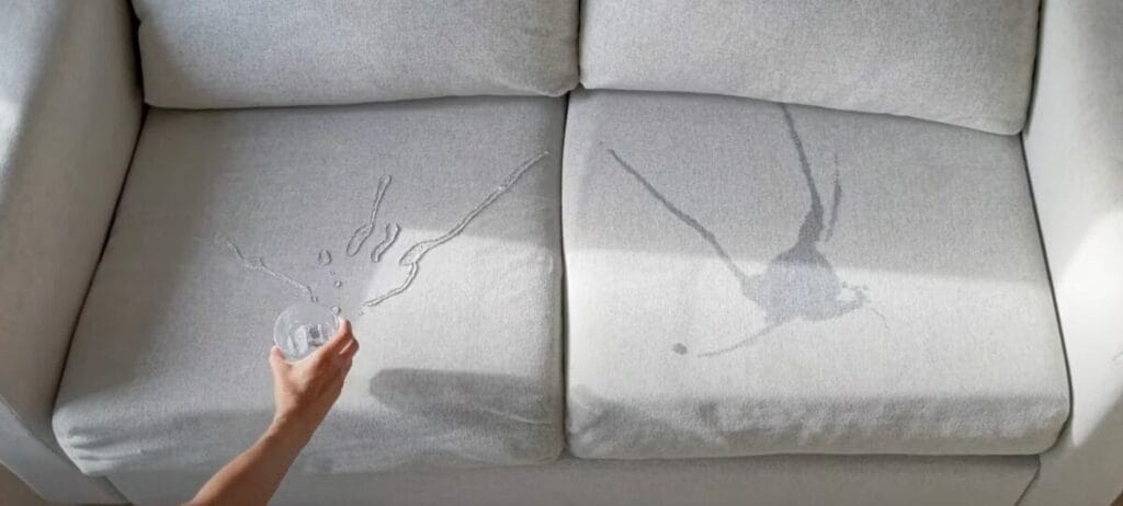 A person spilling water on a couch with nanotechnology in fabrics
