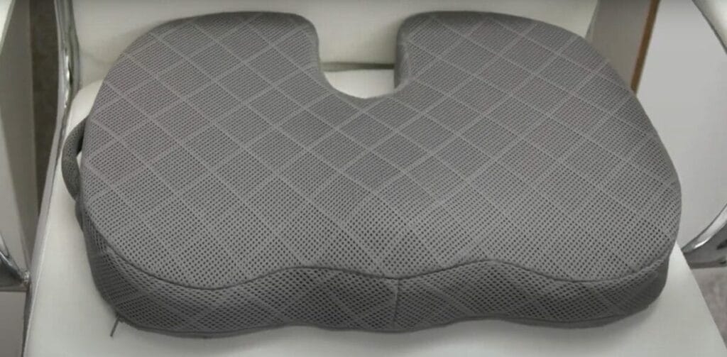 A gray seat cushion on a white chair 