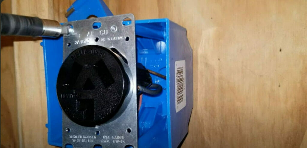 A person attaching the dryer outlet carefully to the blue electrical box