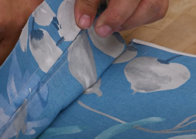 A person holding a fabric with mismatched pattern prints