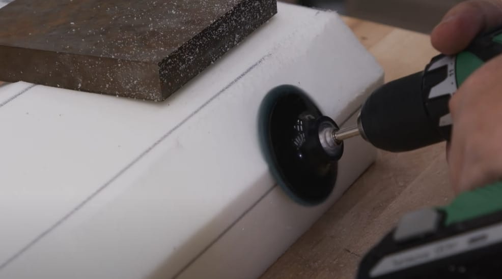 A person working on evening the foam padding