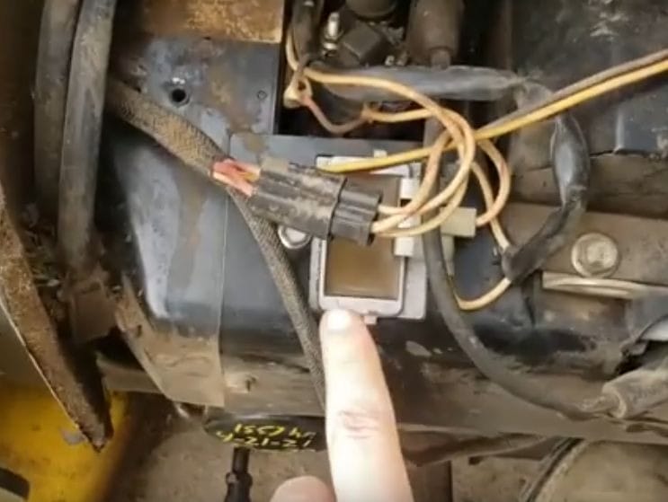 A person locating the John Deere voltage regulator