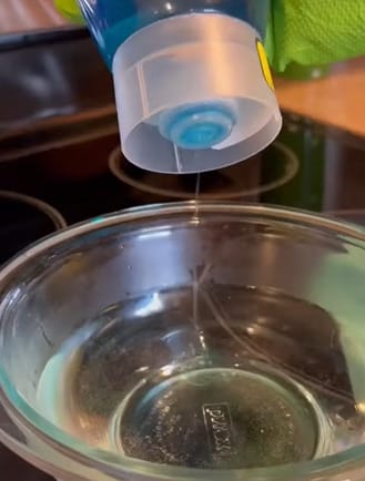 A person is pouring a liquid into a steel bowl