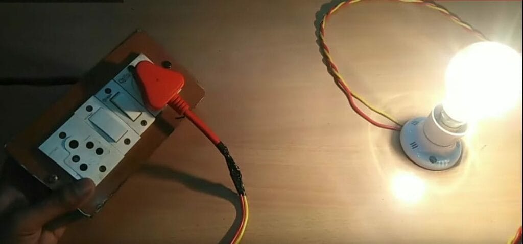 A person wiring a bulb with a 3-prong plug