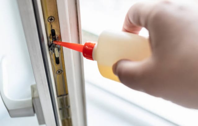 A person is applying a lubricant on a sticky window