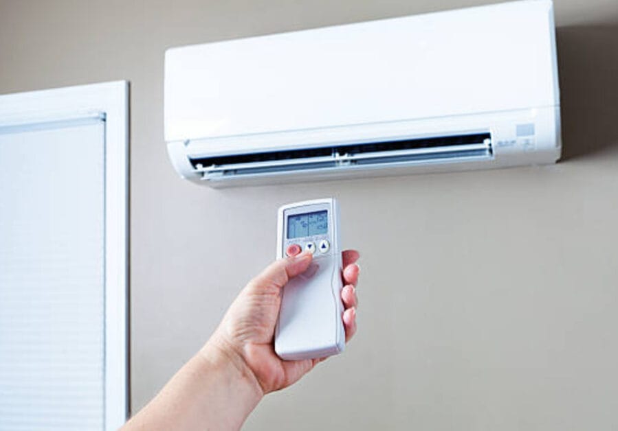 A person using a remote control of an AC