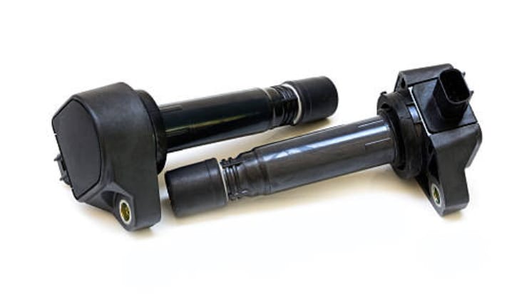 A pair of black spark plugs on a white background alongside instructions on how to test ignition coil with multimeter.